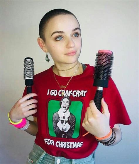 a woman holding two hair brushes in one hand and wearing a t - shirt ...