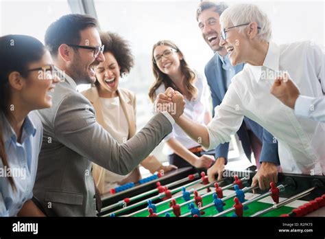 Excited diverse employees enjoying funny activity at work break, creative friendly workers play ...