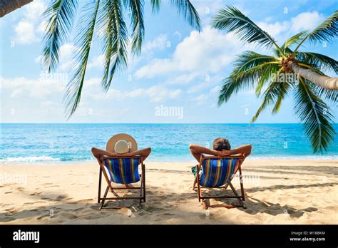 Couple relax on the beach enjoy beautiful sea on the tropical island. Summer beach vacation ...