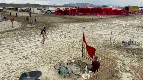 Burning Man festivalgoers urged to seek shelter and conserve food as rain turns site into mud ...