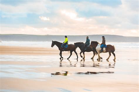 Premium Photo | Horse riding on the beach at sunset in wales