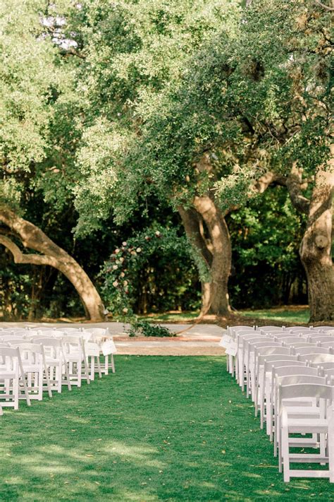 rows of white chairs set up for an outdoor ceremony