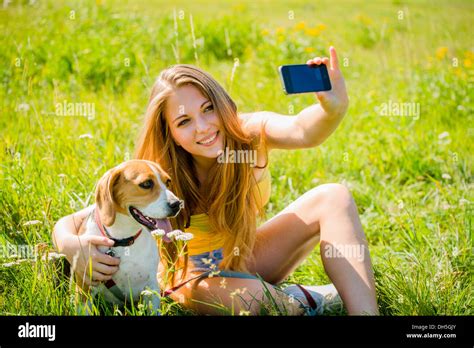 Teen girl taking photo of herself and her dog with mobile phone camera Stock Photo - Alamy
