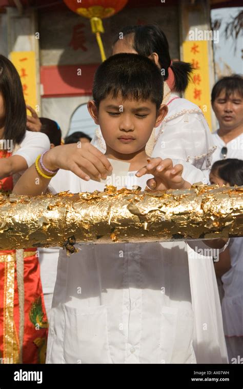 Worshippers pray and place gold leaf before the flag pole raising ceremony at Jui Tui Shine at ...