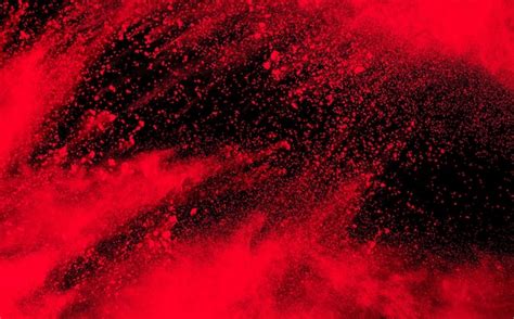 Premium Photo | Red powder explosion on black background. Freeze motion of red dust particle splash.