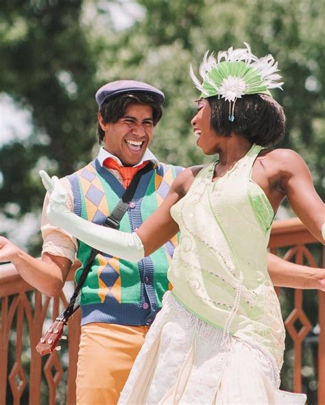 two people dressed in costumes standing next to each other on a bridge with trees in the background