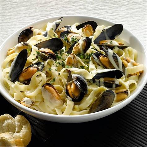 Mussels with creamy white wine sauce, served on a bed of tagliatelle ...