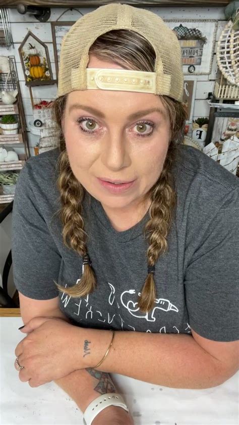 a woman with braids and a hat on her head sitting in front of a table