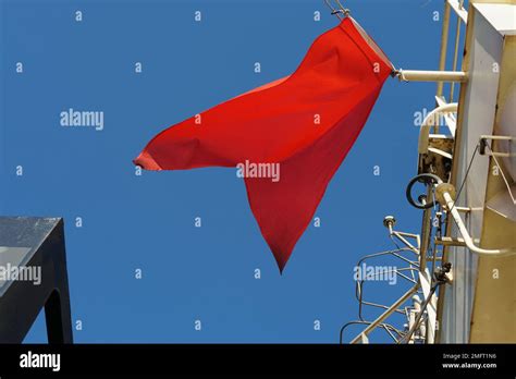 Red flag, international maritime signal flag, flying on the navigational mast of merchant vessel ...