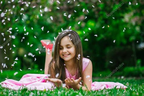 Little girl on green grass with petals Stock Photo by ©Tverdohlib.com 111808798