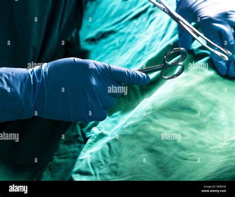 Close-up of gloved hands holding the surgical scissors and working, operating room, hospital ...