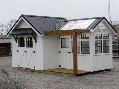 a small white shed with a metal roof