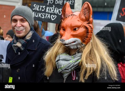 Riga, Latvia. 24th Nov 2018. Young woman (R) with fox mask ...