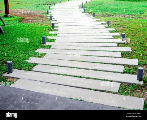 Curved concrete walkway with modern design pattern with garden lights ...