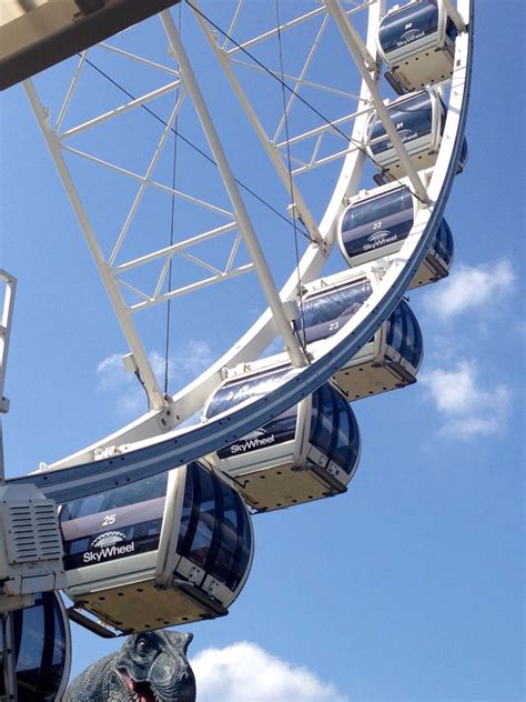 a ferris wheel with blue sky and clouds in the background