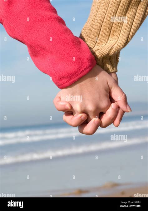 Lovers couple holding hands on beach at winter Stock Photo - Alamy