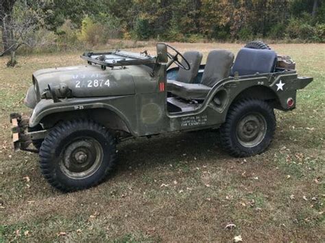 an old army jeep is parked in the grass