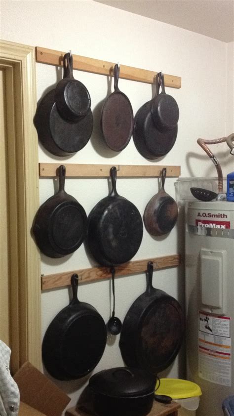 Hang your cast iron pans from pieces of 2X4 with hooks in em. I would paint them however ...