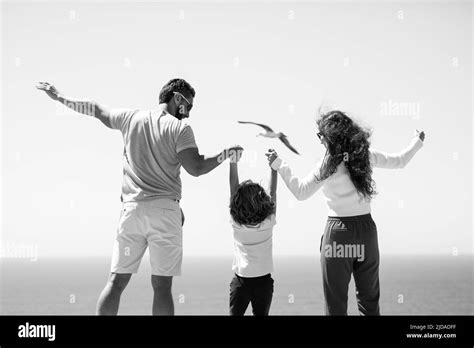 Back view of happy family on the beach vacation Stock Photo - Alamy