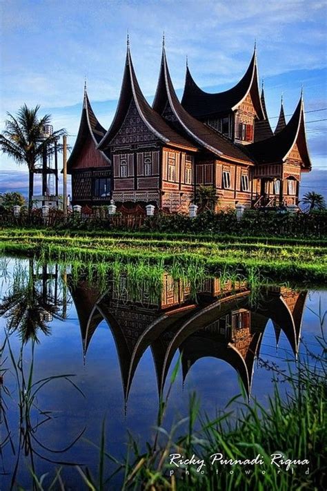 an old wooden house is reflected in the water