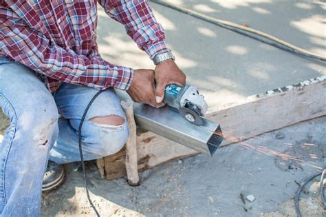 Premium Photo | Worker cuts a metal pipe with some electric device or appliance