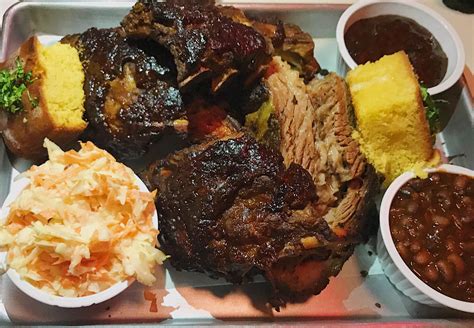 Smoked Brisket and Baby Back Ribs served with Cornbread, Beans and Coleslaw at Little Wolf ...