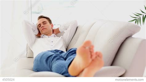 Calm Young Man Sleeping On Couch Stock video footage | 4505024