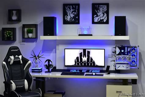 a computer desk with two monitors and speakers on top of it in front of ...