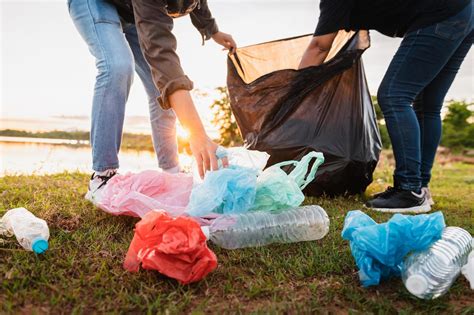 woman hand picking up garbage plastic bag for cleaning at park 8423314 Stock Photo at Vecteezy