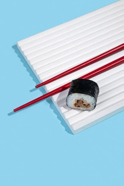 Premium Photo | Hosomaki sushi rolls with eel on a white plaster stand on a blue plain background