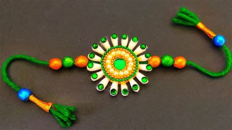 a green and white beaded bracelet with tassels on it's sides