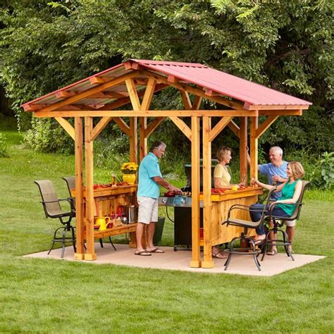 a group of people sitting around a wooden gazebo on top of a lush green ...