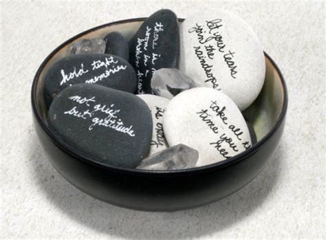 a bowl filled with lots of black and white rocks next to each other on top of a table