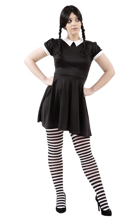 a woman in black dress and striped stockings posing with her hands on ...