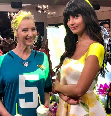 two women standing next to each other holding cupcakes