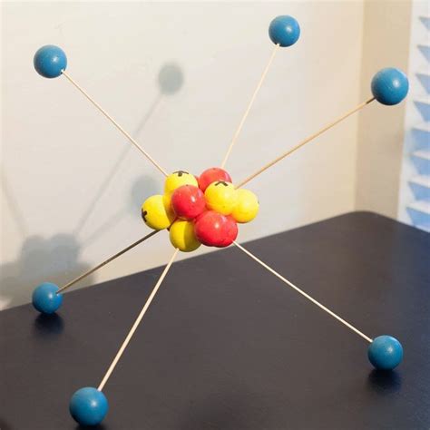 a table with some balls and pins on it in front of a window that has blinds