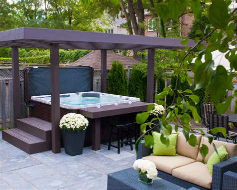 a hot tub sitting on top of a patio next to a table and couches