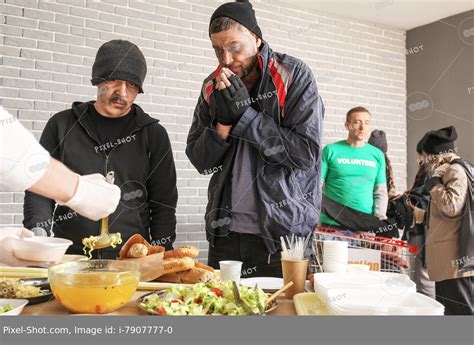 Volunteer giving food to homeless people in warming center :: Stock ...