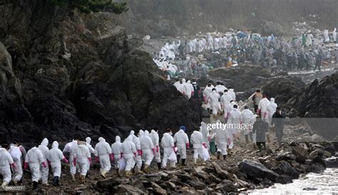 Volunteers, residents and soldiers march along the coast to remove... News Photo - Getty Images