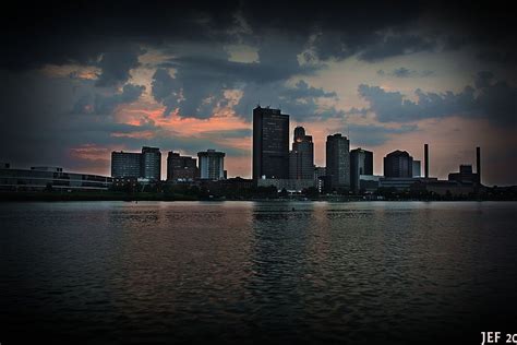 the city skyline is silhouetted against a cloudy sky