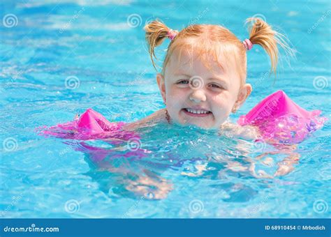 Little Girl with Over-sleeves Floats in Pool. Stock Photo - Image of ...