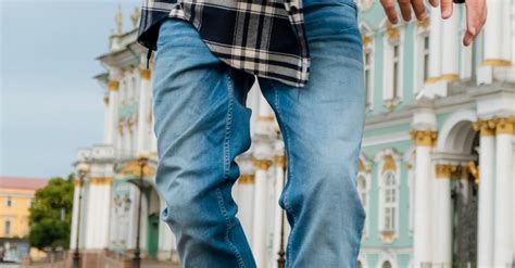 Person in Blue Denim Jeans and Plaid Shirt Standing on Road · Free Stock Photo