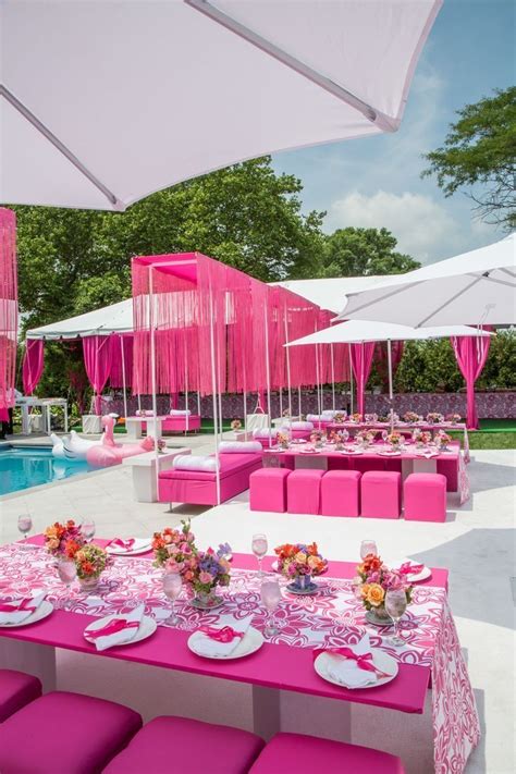 an outdoor dining area with pink and white tables, chairs, and umbrellas over the pool