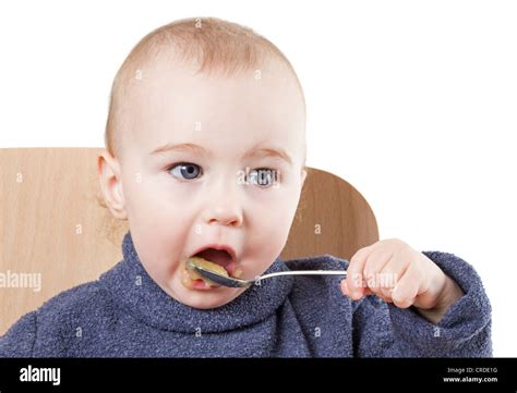 baby eating applesauce - studio shot isolated on white background Stock Photo - Alamy