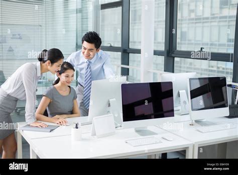 Young business people using computer in office Stock Photo - Alamy