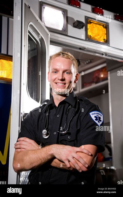 Smiling paramedic standing in front of ambulance Stock Photo - Alamy