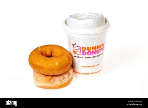 A hot styrofoam cup of Dunkin Donuts coffee with plain and jelly ...