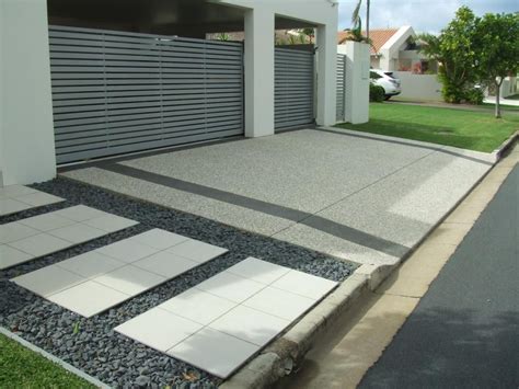 a driveway with gravel and stones in front of a house