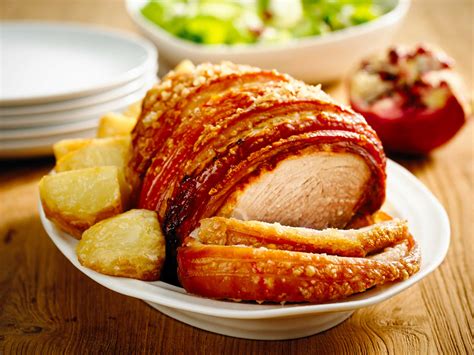 Crackling pork leg roast with roasted potatoes and festive green salad ...