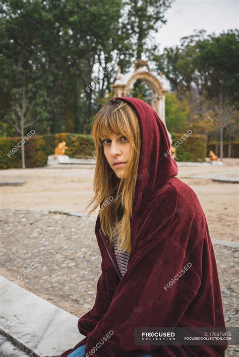 Brunette girl in red hoodie looking at camera — tranquil, attraction ...